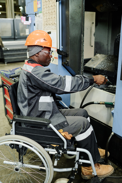 Worker with disabilities operating heavy machinery in industrial setting